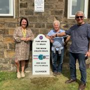 Headteacher, Naomi Healey, artists  Shane Johnstone and Cliviger Parish Council chairman, Ivor Emo with the milestone.