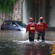 Emergency service rescuing several person from a vehicle after flooding