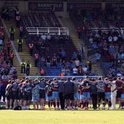 The Burnley squad in a huddle after the final whistle