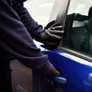 A stock image of a person trying a vehicle door