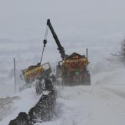 Lancashire County Council gritter being pulled out of snow drift in Blacko