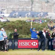 ILLUSTRIOUS COMPANY: Clitheroe’s Mark Young (left) watches Justin Rose tee off at St Andrews yesterday