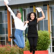 from left, Fiza Amadali 16 jumps for joy with Zarah Mahmood also 16 as they celebrate their exam results at Pleckgate