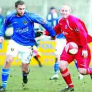 DETERMINED: Player-manager Phil Eastwood, in red, battles for the ball	Picture: KIPAX