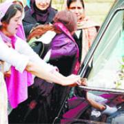 OVERCOME: Daughter Kawal Shafiq clings to the hearse carrying her father