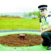 THEFT: PC Phil Hambley inspects the spot the roundabout stood before it was stolen