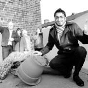 Community engagement officer Asif Iqbal launches the skip watched by residents and officials.
