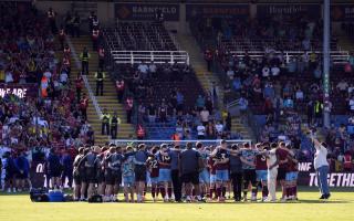 The Burnley squad in a huddle after the final whistle