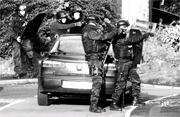 FLASHBACK: Armed officers outside the house where the siege took place
